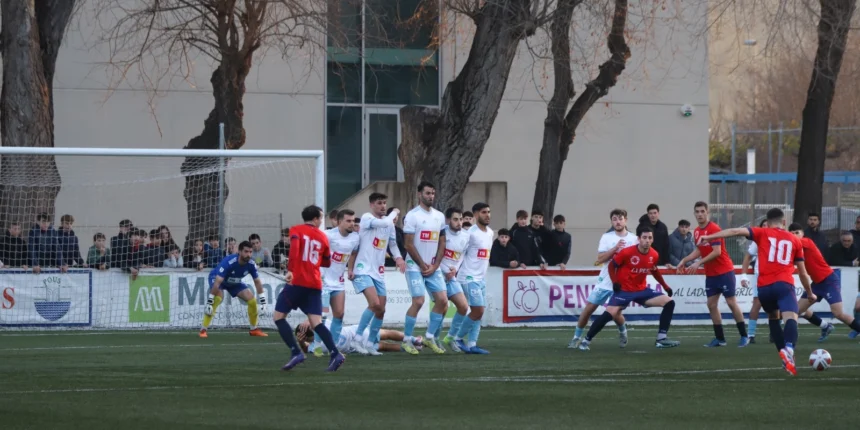 Jugadores del S.C. Torrevieja C.F. y el Tavernes de Valldigna en plena acción durante un partido de la jornada 20 de la Liga Comunidad. Un momento clave del encuentro con el equipo local defendiendo su área