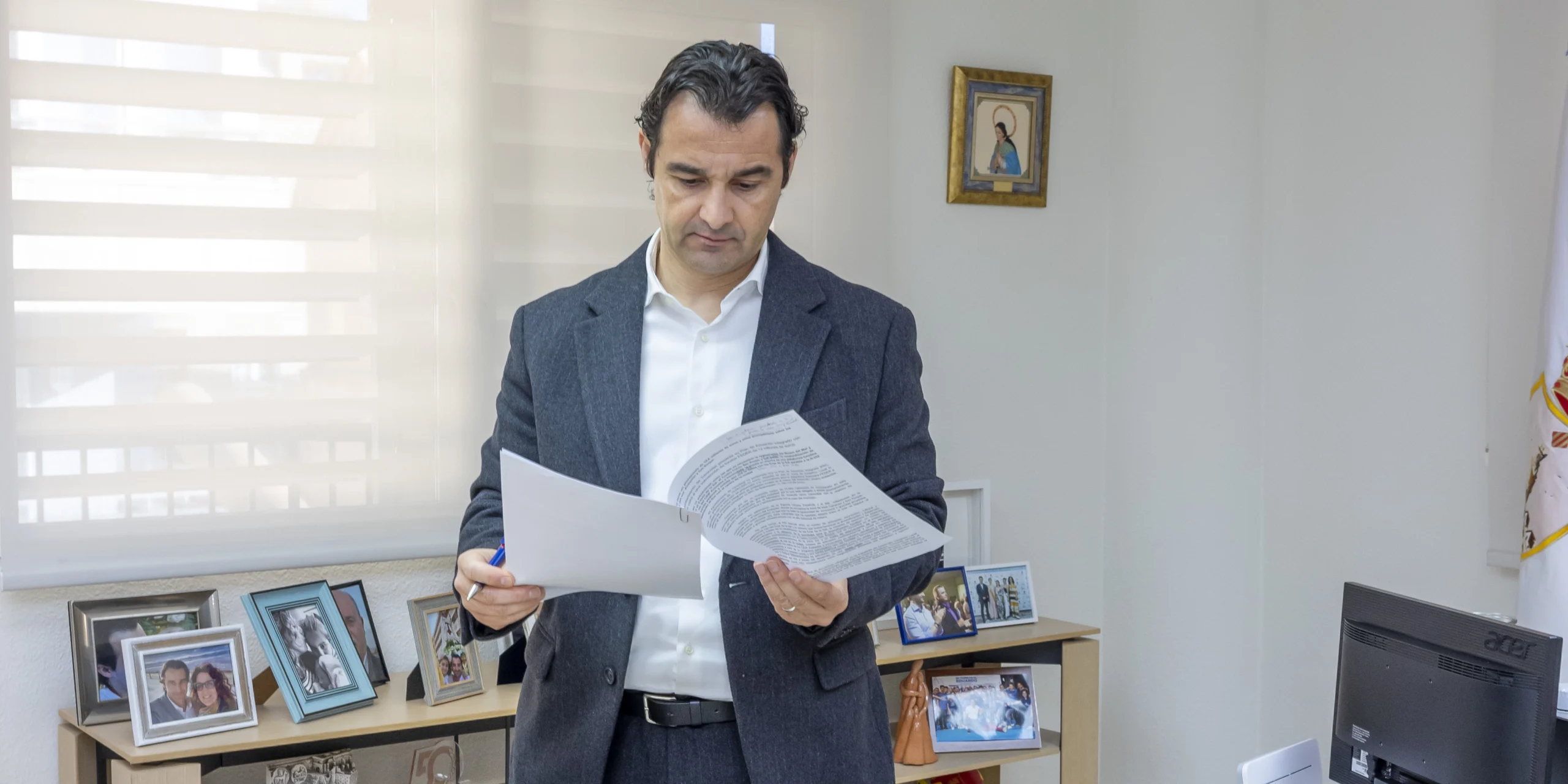 El alcalde de Torrevieja, Eduardo Dolón, revisa documentos en su despacho, con fotografías familiares de fondo