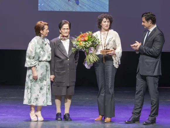 Acto de entrega del Premio Día de la Mujer 2025 a Rosario Carmona en el Centro Cultural Virgen del Carmen, acompañada por autoridades locales y familiares