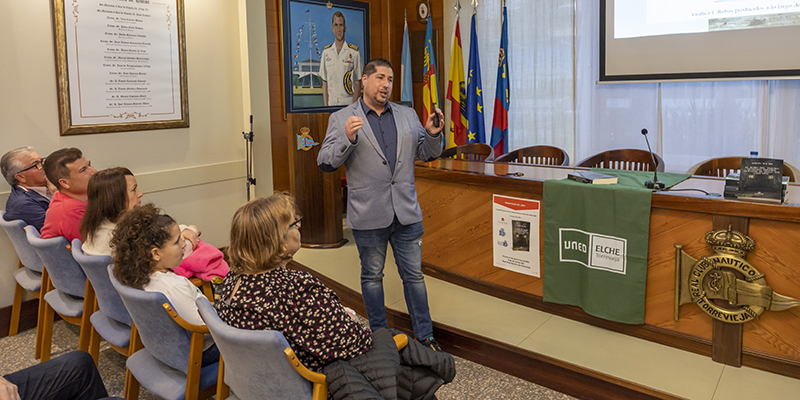 Sergio Boj durante la presentación de su libro en el Real Club Náutico de Torrevieja, acompañado por público asistente y material audiovisual explicativo.