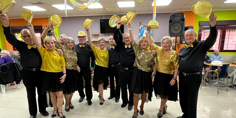 alt=“Grupo de mayores con trajes dorados en la fiesta verde y amarilla celebrada en la Casa de la Tercera Edad Restituto Marroquí durante la Semana del Mayor en Torrevieja.”