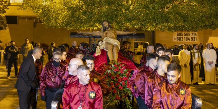 Cargadores portando a hombros el trono con la imagen del Cristo Crucificado