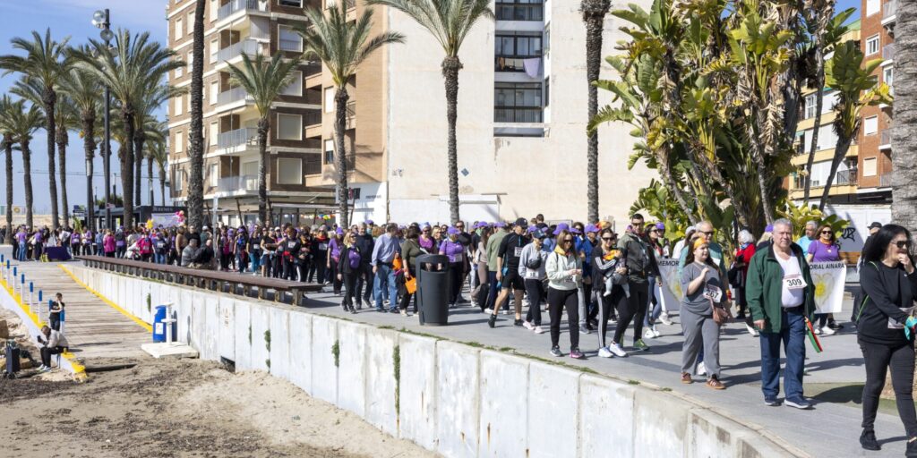 ucha gente caminando por el paseo marítimo de Torrevieja en la marcha solidaria