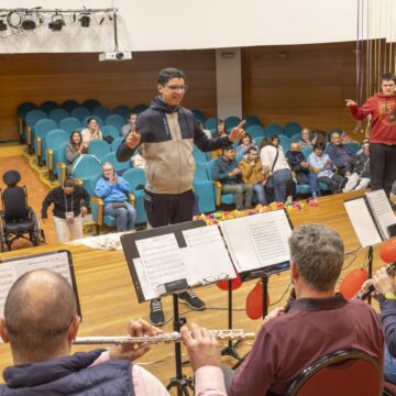 Profesores del conservatorio con sus instrumentos interactuando con alumnos en el Palacio de la Música