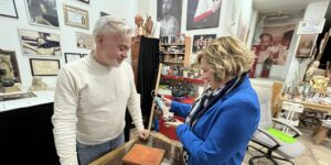 Eva Fernández Huéscar y el escultor Víctor García observando una pequeña figurilla en el taller del artista