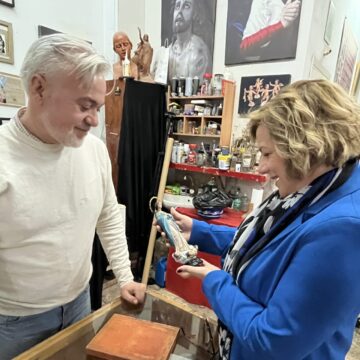 va3455-pregonera Eva Fernández Huéscar y el escultor Víctor García observando una pequeña figurilla en el taller del artista