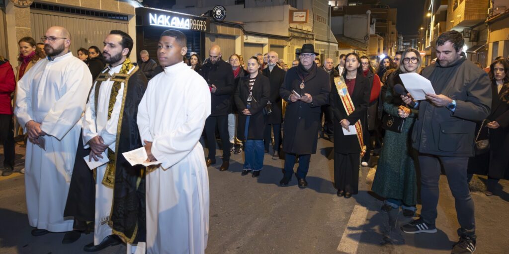 Grupo de sacerdotes y autoridades locales participando solemnemente en el rezo del Vía Crucis nocturno