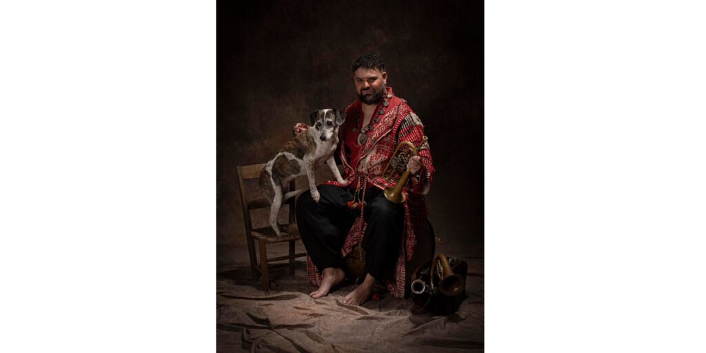 El músico Abraham Cupeiro sentado con un perro y varios instrumentos de viento ancestrales que forman parte de su espectáculo Pangea