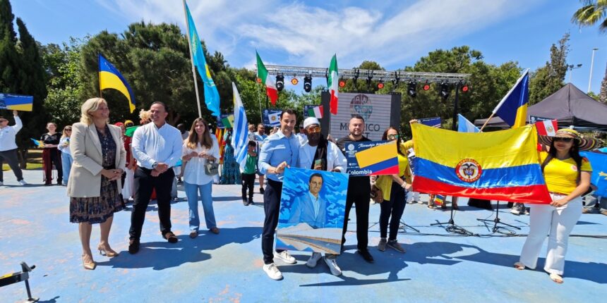 va3460-mosaico fest Personas de diversos países sujetando banderas al lado de Eduardo Dolón durante el Mosaico Fest de Torrevieja