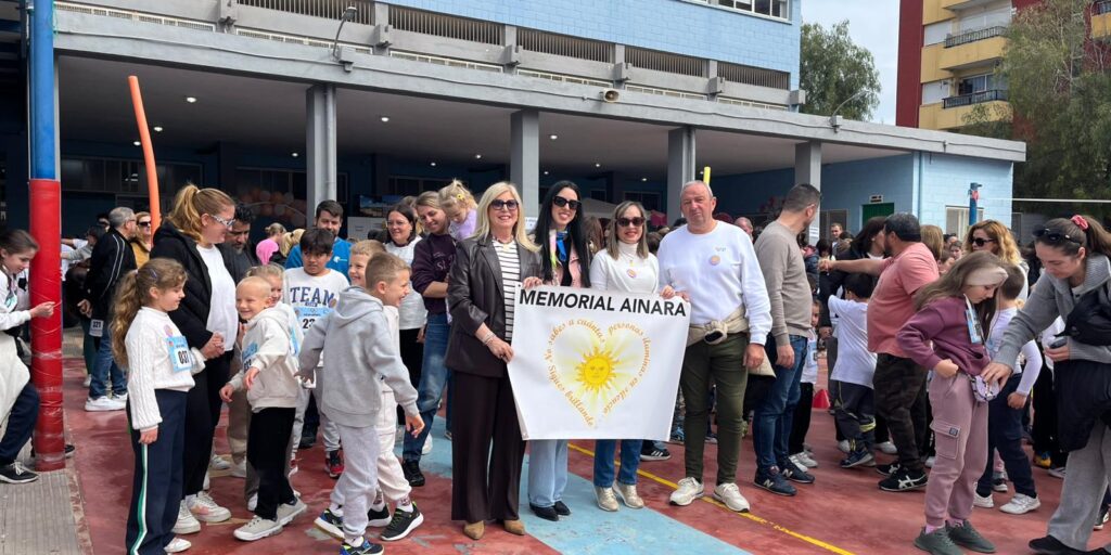 Mujeres sujetando una pancarta Memorial Ainara rodeadas de los jóvenes participantes