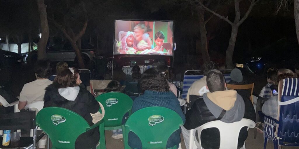 Vecinos de todas las edades disfrutan de una velada de cine al aire libre proyectada
