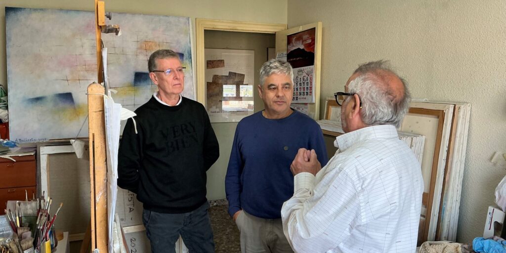 Antonio Ballesta conversando en su taller con el comisario Jesucristo Riquelme y otro acompañante