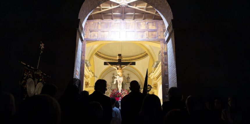 Fieles contemplando la imagen del Cristo Crucificado desde el umbral de la Iglesia