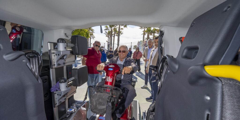 Un usuario accede al interior de uno de los nuevos eurotaxis utilizando un scooter de movilidad