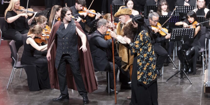 Varios personajes siendo representados en el escenario junto a la banda