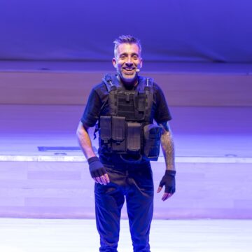 Uno de los protagonistas del espectáculo “Misión Impro-sible” sonríe sobre el escenario del Auditorio Internacional de Torrevieja ataviado con un chaleco táctico como parte de su personificación cómica