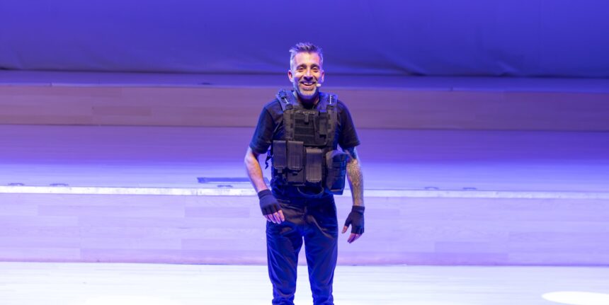 Uno de los protagonistas del espectáculo “Misión Impro-sible” sonríe sobre el escenario del Auditorio Internacional de Torrevieja ataviado con un chaleco táctico como parte de su personificación cómica