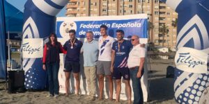 Los premiados del Open de Beach Sprint posan frente al cartel de la Federación Española de Remo