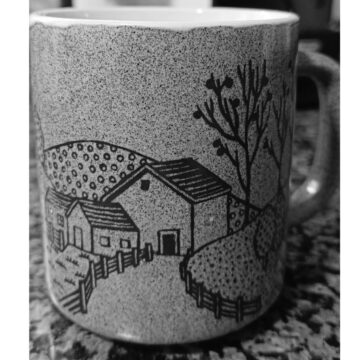va3458-cuaderno primavera Una taza con diseño de un paisaje rural con casas, cercas y árboles
