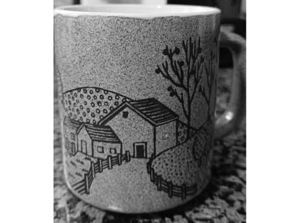Una taza con diseño de un paisaje rural con casas, cercas y árboles