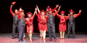 Grupo de mayores vestidos de gala en una actuación de baile durante la Gala de Fin de Curso de las actividades artísticas de Gente Mayor
