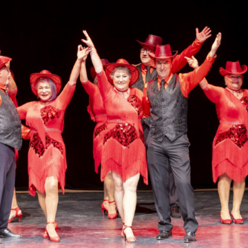 Grupo de mayores vestidos de gala en una actuación de baile durante la Gala de Fin de Curso de las actividades artísticas de Gente Mayor