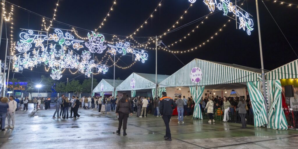 El recinto ferial del Parque Antonio Soria presenta un ambiente concurrido junto a las casetas de rayas blancas y verdes bajo la iluminación nocturna de la festividad