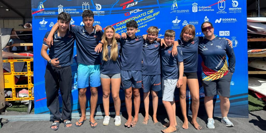 Equipo de regatistas y entrenadora del Real Club Náutico de Torrevieja frente al panel oficial del Campeonato de España de Windsurf en La Palma