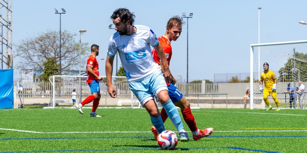 Un futbolista del SC Torrevieja controla el balón durante el dominio del juego frente al UD Rayo Ibense en el estadio Nelson Mandela