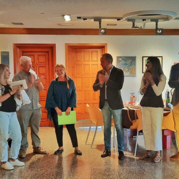 Representantes municipales y de asociaciones benéficas aplaudiendo durante la apertura de la exposición solidaria "El mundo que nos rodea" en el Real Club Náutico de Torrevieja