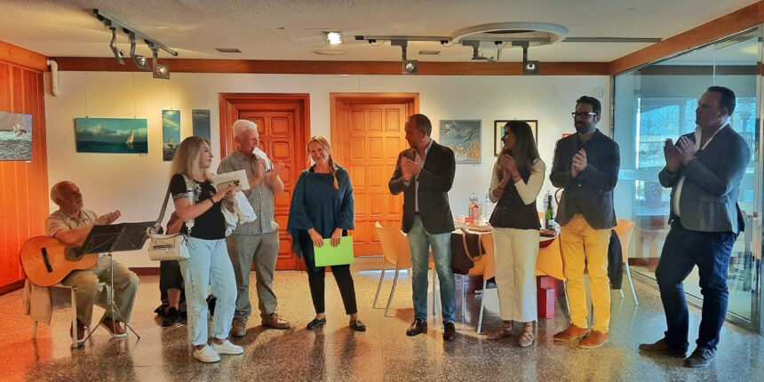 Representantes municipales y de asociaciones benéficas aplaudiendo durante la apertura de la exposición solidaria "El mundo que nos rodea" en el Real Club Náutico de Torrevieja