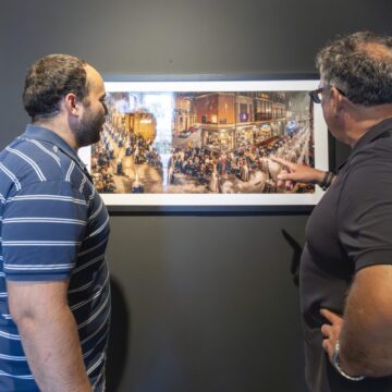 Visitantes observan la exposición fotográfica sobre la Semana Santa de Cartagena en la Sala Vista Alegre de Torrevieja
