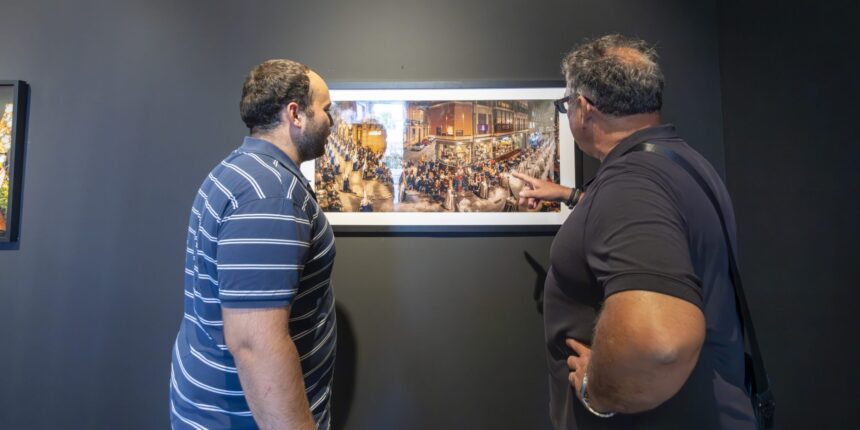 Visitantes observan la exposición fotográfica sobre la Semana Santa de Cartagena en la Sala Vista Alegre de Torrevieja