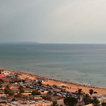 Vista de la playa de La Mata en Torrevieja durante una jornada de sol y nubes