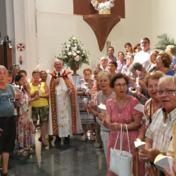 Fieles con velas durante la vigilia de la Asunción de la Virgen María en la parroquia del Sagrado Corazón de Torrevieja.