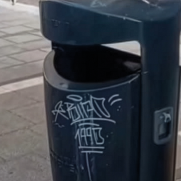 Papelera del mobiliario urbano de Torrevieja con pintadas vandálicas antes de los trabajos municipales de limpieza.
